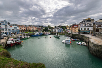 Fototapeta na wymiar Port area of Puerto de Vega town in Asturias, Spain with beautiful blue waters and fishing boats.