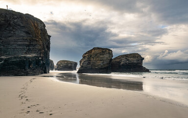 Fototapeta na wymiar Scenic Playa de las Catedrales (Beach of the Cathedrals) featuring stunning rock arches, during low tide.