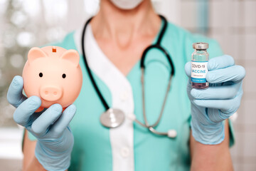 Doctor hands protected with gloves holds vaccine vial and piggy bank. Expensive vaccinations,...