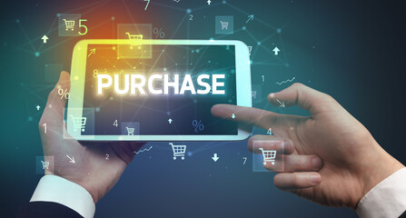 Close-up of a hand holding tablet with PURCHASE inscription, online shopping concept