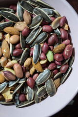 A mixture of different types of nuts and seeds. Ground nuts, almonds, seeds.