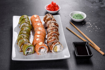 Fresh tasty sushi rolls laid out in the form of a dragon with ginger and wasabi