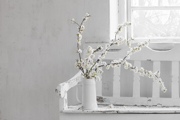 cherry flowers in white jug on old wooden bench