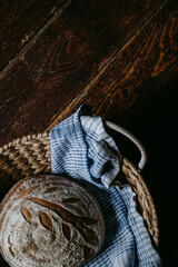 Traditional handmade, homemade sourdough bread in the basket, wooden background, blue teatowel