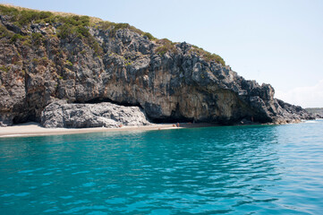 Obraz premium The end of the rocky ‘Troncone’ beach with a turquoise sea, Marina di Camerota, Italy. Naturism. 