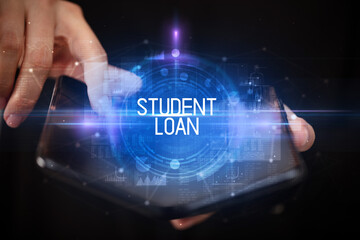 Fototapeta premium Young man holding a foldable smartphone with STUDENT LOAN inscription, educational concept