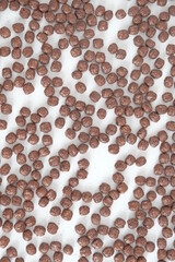 Chocolate corn balls scattered on a white background. Top view. Copy, empty space for text