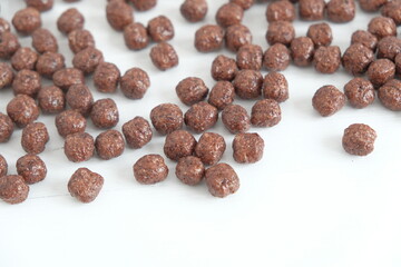 Chocolate corn balls scattered on a white background. Top view. Copy, empty space for text