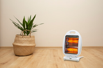 Front view, hallogen light heater standing on parquet floor