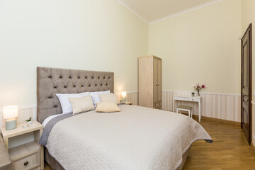 modern bedroom interior, with large bed. in light colors, beige