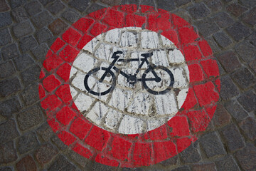 Traffic sign no bicycles painted on paving stones.