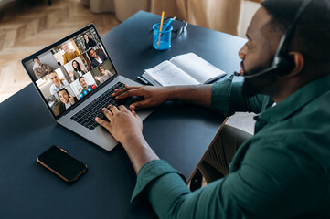 Fototapeta na wymiar Business brainstorm, online video meeting, virtual conference with multiracial colleagues. African American man communicate with business partners by video call uses laptop and app, work from home