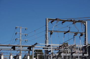 Low angle view of parts of an electricity substation on an ocean bluff under blue sky