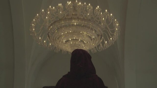 man looking at the big chandelier in the ceiling