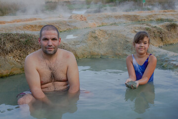 Children and parents have a joint vacation in the mountains, swimming in wild hot mineral springs in the open air.