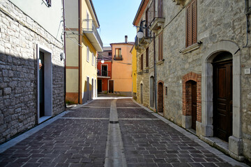 Fototapeta na wymiar A street among the old stone houses of Castelpagano, a medieval village in the province of Benevento.