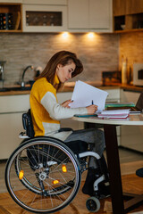 Woman in wheelchair writing her homework