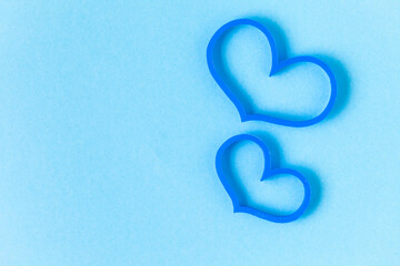 Two blue heart shaped figures on the light blue background. Love concept.