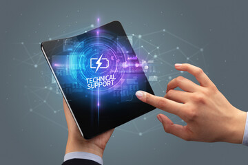 Businessman holding a foldable smartphone with INDUSTRY 4.0 inscription, new technology concept TECHNICAL SUPPORT