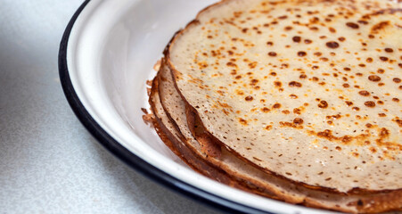Fresh baked pancakes in a white metal cup. Selective focus.