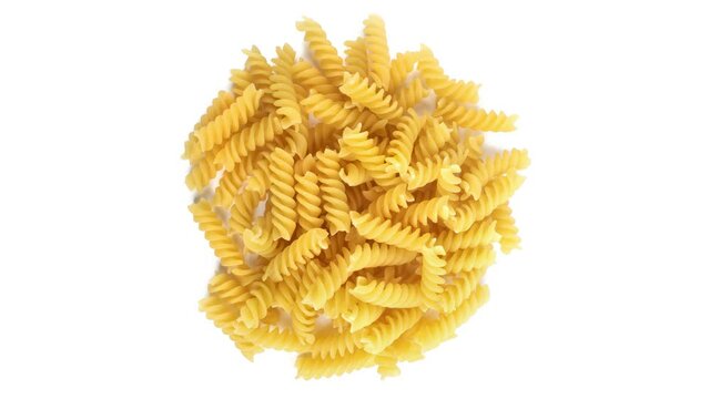 Slowly rotating pile of fusilli pasta on white background