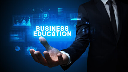 Hand of Businessman holding BUSINESS EDUCATION inscription, business success concept