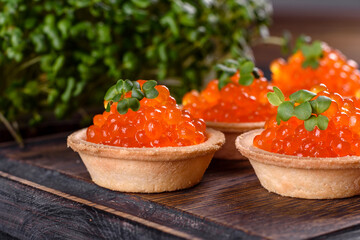 Delicious fresh red caviar on a dark concrete table
