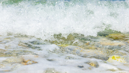 Sea wave and pebble. Summer vacation concept. Sea wave with foam incident on the coastal shingle. Travel concept