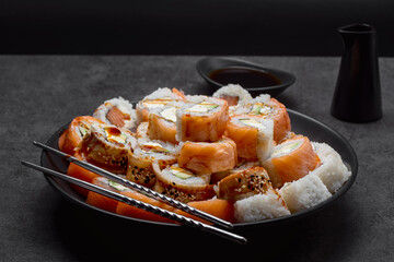 Sushi set in plate on the dark background