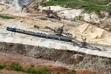excavator loads clay into wagons