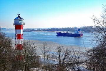 Frachter und Eisschollen auf der Elbe beim Leuchtturm Wittenbergen