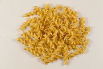 Heap of raw fusilli pasta on gray background