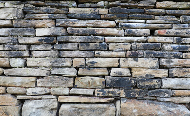 Weathered wall from wild stones, retro surface