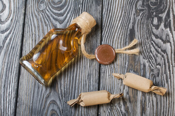 Gift alcohol. A bottle of alcohol lies on the boards. Nearby candy. Close-up shot.