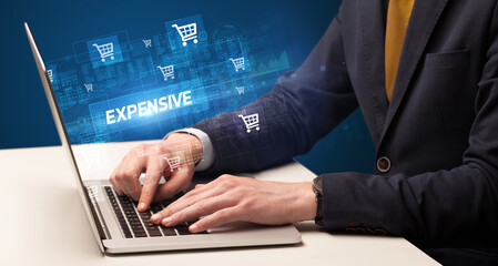 Fototapeta na wymiar Businessman working on laptop with EXPENSIVE inscription, online shopping concept