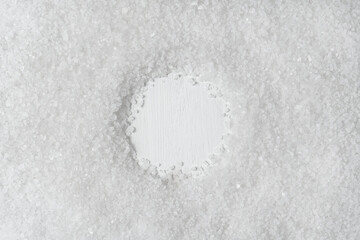 Background from white sea salt. Copy space is round. Coarse rock salt texture
