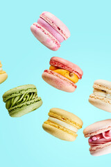 Close up of Traditional french cookies macarons of different types colors and taste isolated on blue background. Sweet cookies macaron. Mockup for the card on the celebrated birthday.