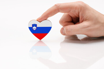 Slovenia flag. Love and respect Slovenia. A man's hand holds a heart in the shape of the Slovenia...