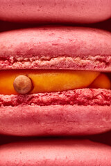 Macro plan of pink French macaroons. Close up of the cream filling with different toppings and fluffy cookies.