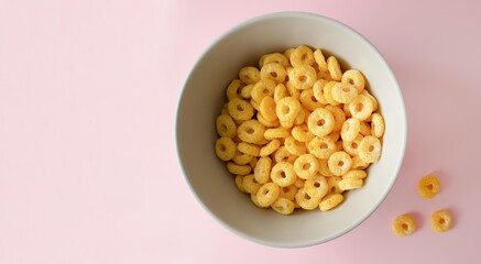 Bowl of breakfast cereal in pink background. Healthy Cereal Rings. Space for text. Top view. Flat lay.