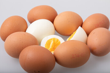 Hard boiled egg with shell and peeled boiled egg on white background