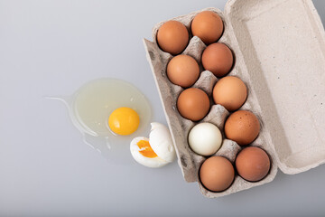 Top view of raw chicken eggs in egg box on white background