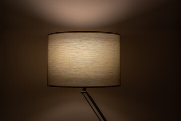 Close up of one indoor table lamp with cloth fabric. Home interior design with soft cozy glow.