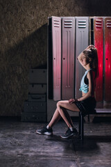 young girl stands in an atmospheric fitness room against the background of lockers for changing room