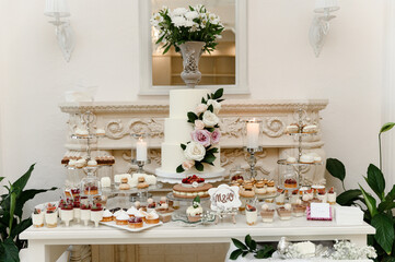 a lovely wedding cake standing among the candy bar. sweet table. banquet table. holiday food. sweet festive table.