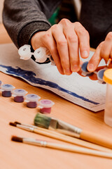 The guy paints a picture by numbers. Watercolor paints. Painting brush, Painting by numbers concept