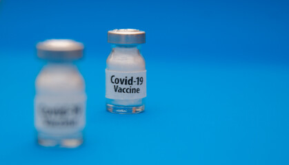 Coronavirus vaccine concept and syringe on blue background with copy space