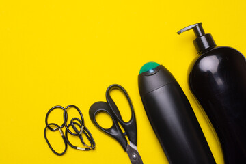 Black shampoo on the background of copyspace. A bottle of shampoo. Yellow background. Article about the beauty industry.