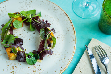 gourmet salad with sweet bread, carpaccio raw venison deer meat and creme de cassis