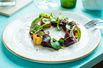 gourmet salad with sweet bread, carpaccio raw venison deer meat and creme de cassis